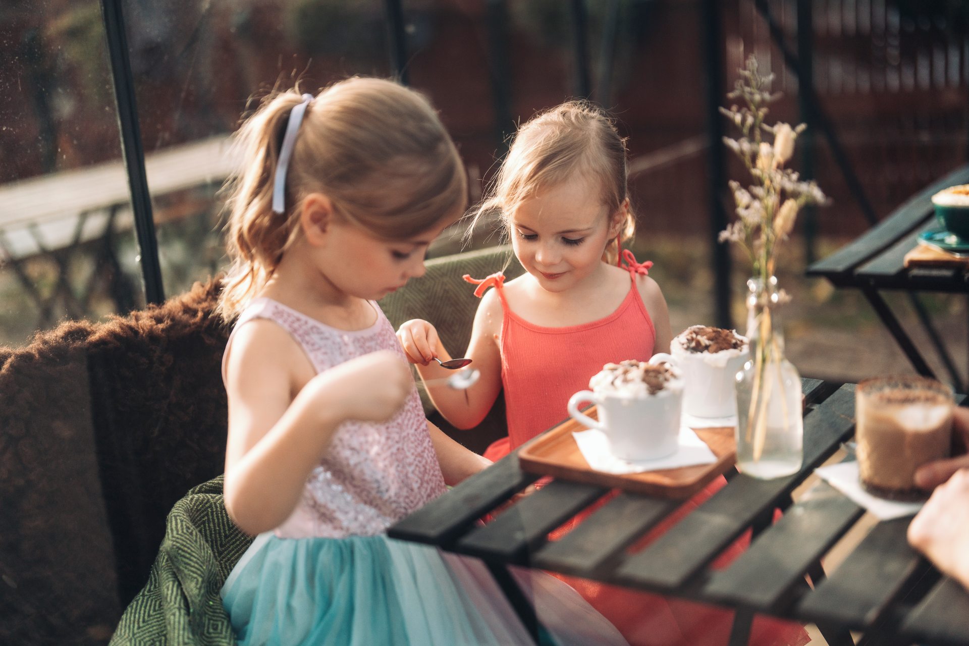 Kaksi lasta kahvilan pöydässä